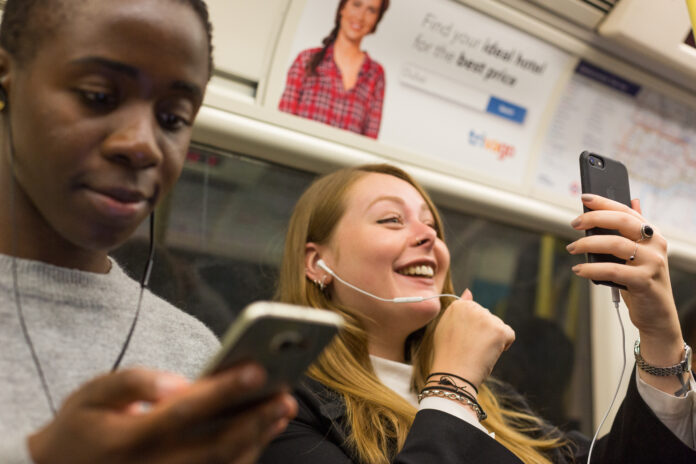 Commuters using their phones in a tunnel on the jubilee line.